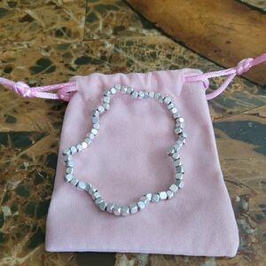 Silver Beaded Bracelet And Pink Pouch